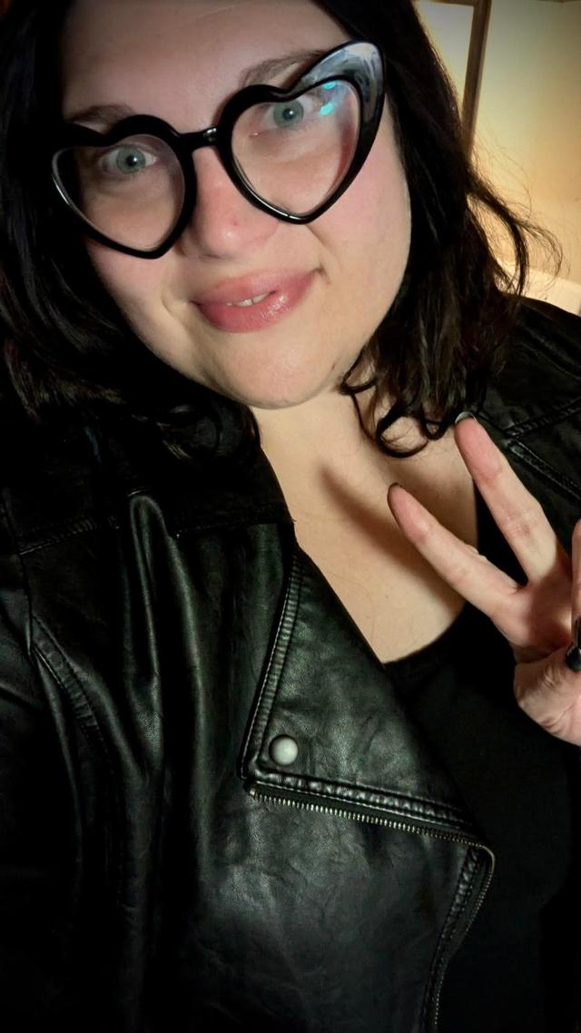 Sam Cole picture wearing black holding the peace sign.