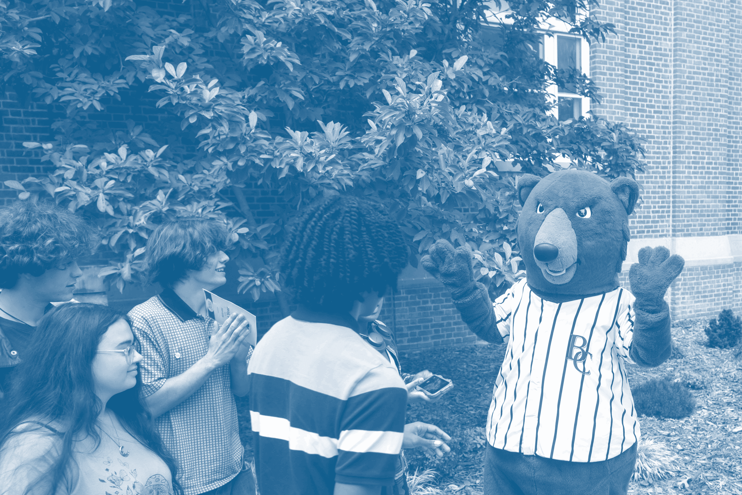 Berea's mascot, Blue the bear, greeting a group of students.